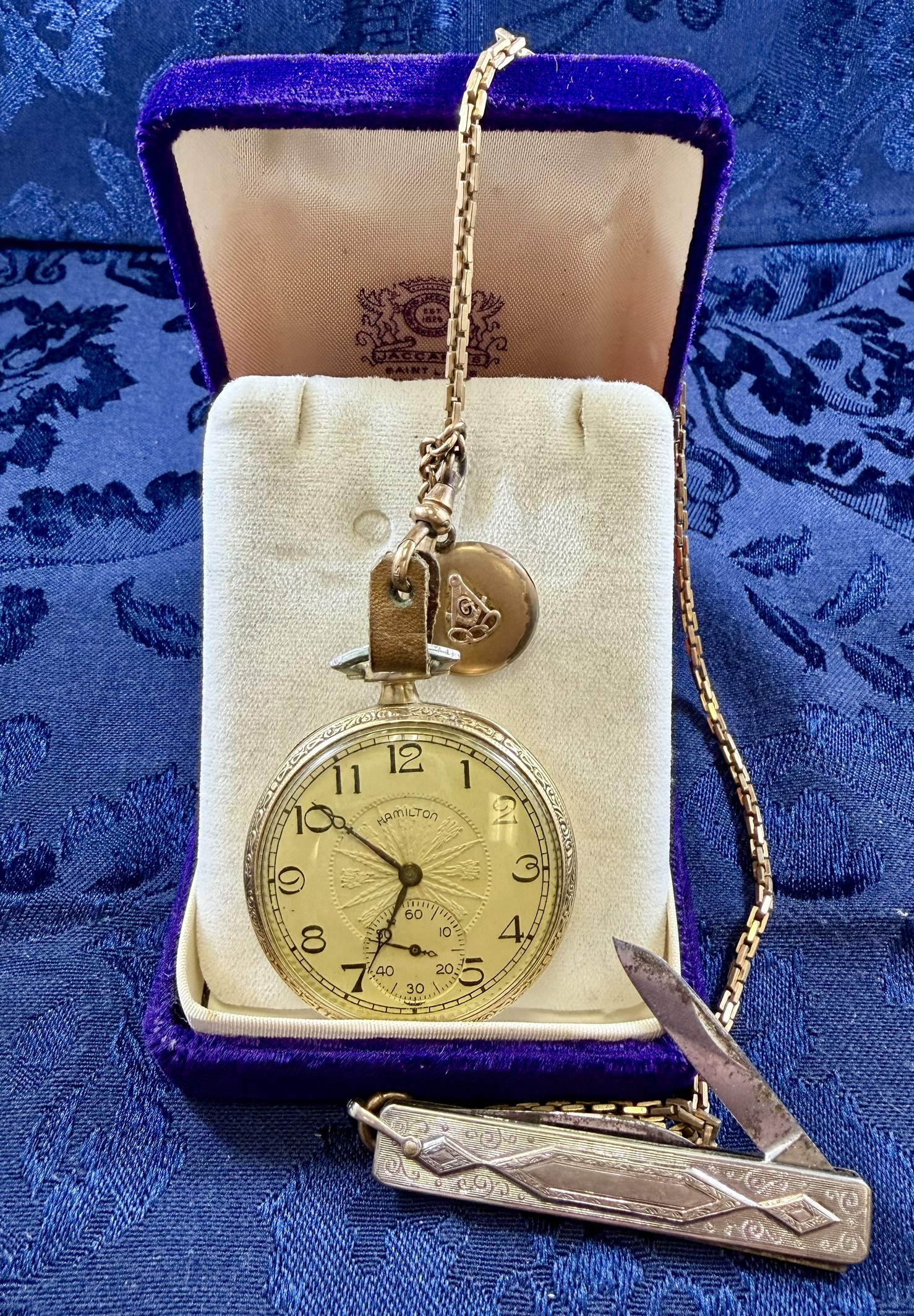 Gold Colored Hamilton Pocket Watch (17 Jewel Pocket) with Fob, Locket, and Silver Colored Pocket Knife · Lot 1699